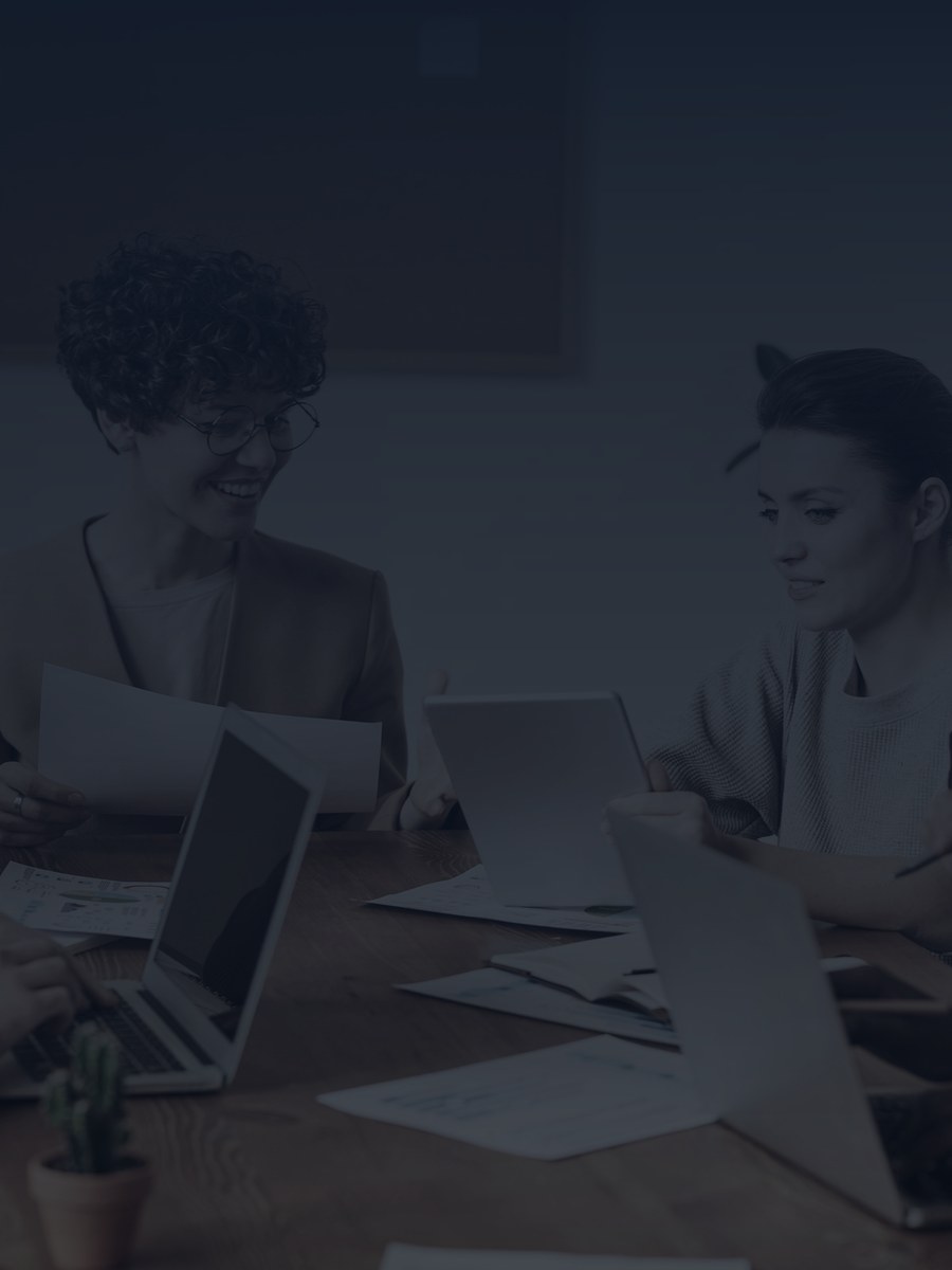 Colleagues reviewing documents and laptops around a meeting table